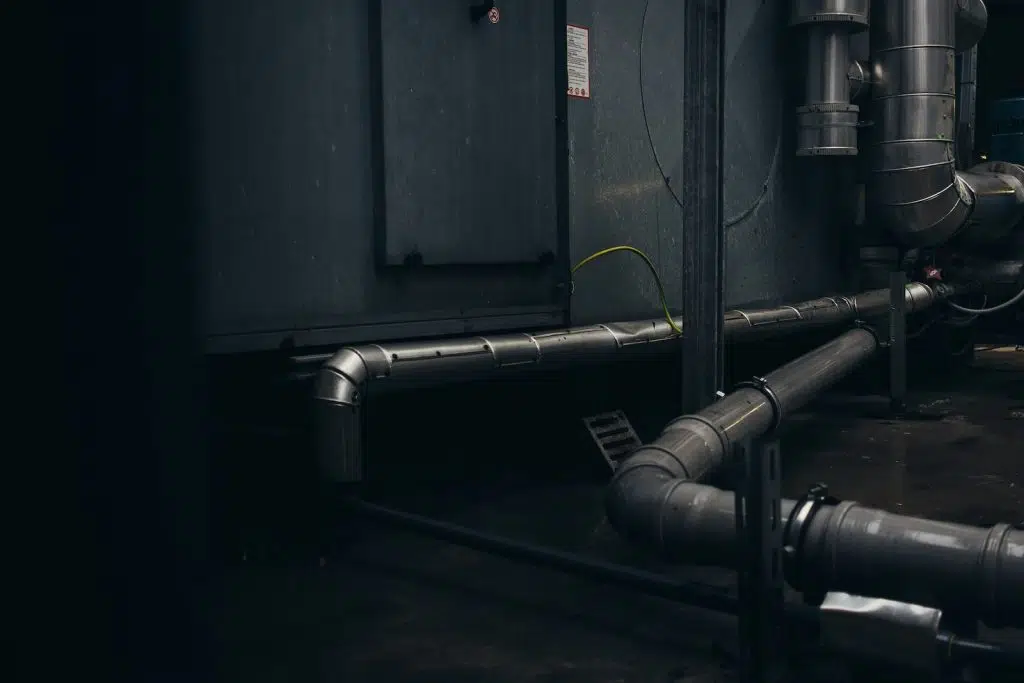 gray pipes mounted on concrete wall arrangement